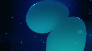 Soyut lav baloncukları sıvı halindeki mavi arkaplana doğru akıyor. Yavaş çekim. 