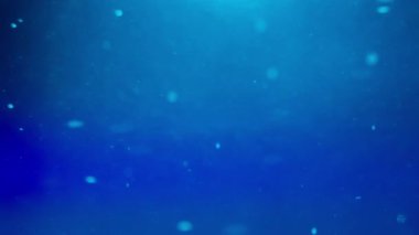 Mavi arkaplana karşı sıvı içinde akan küçük soyut parçacıklar. Yavaş çekim.