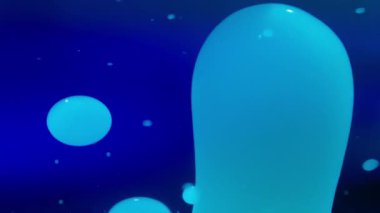 Mavi arka planda sıvı halindeki lav kabarcıkları. Soyut, yavaş çekim. 