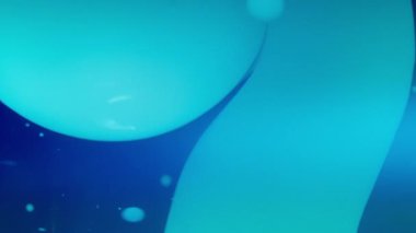 Mavi lav kabarcıkları koyu arkaplanda sıvı olarak akıyor. Yavaş çekim, soyut. 