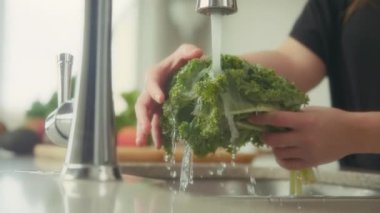 Mutfak lavabosunda taze lahana yıkayan bir kadın. Yavaş çekim. 