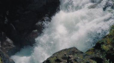 Güçlü bir şelale kayalara çarpıyor. Yavaş çekim. 