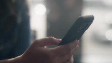 Kapıda beklerken akıllı telefonuyla kayan bir kadının fotoğrafını çek. Yavaş çekim.