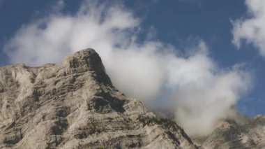 Bulutlarla kaplı Rocky Dağları 'nın yüksek tepelerinden geçiyoruz. Yavaş çekim.