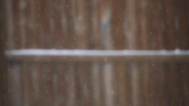 Tahta çitlerin arkasında kar yağışı var. Yavaş çekim.