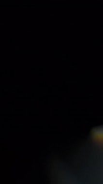 Işık sızıntıları ve gökkuşağı prizmasının yansımaları üst üste biniyor. Ağır çekim. Dikey Biçim.