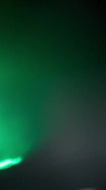 Cam prizma kırıklarından oluşan bir sürü yavaş çekim yeşil ışık sızıntısı. Dikey Biçim.