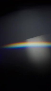 Cam prizma yansımasından oluşan soyut ışık sızıntıları sürüsü. Ağır çekim. Dikey Biçim.