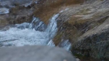 Kayalıklardan akan su akıntısını kapatın. Yavaş çekim.