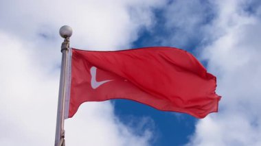 Bulutlu gökyüzüne karşı rüzgarda dalgalanan Belçika bayrağı. Yavaş çekim.