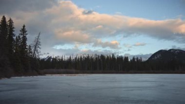 Gün batımında donmuş gölün üzerinde hareket eden bulutlar. Zaman Süreleri.