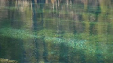 Kanada 'daki Grassi Gölleri' nin yansıması olan yeşil su yüzeyi. Yavaş çekim.