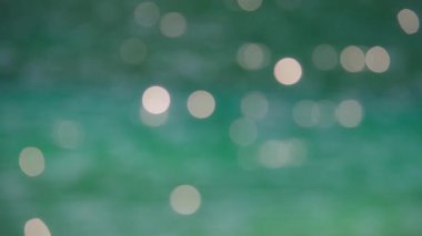 Soyut Bokeh güneş ışığı turkuaz göl yüzeyinde parlıyor. Yavaş çekim.