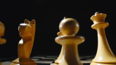 Satranç tahtasındaki beyaz ahşap satranç taşlarından Dolly makro shot. Yavaş çekim.