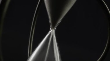 Beyaz kumla dönen klasik kum saatinin soyut görüntüsü.