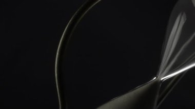 Beyaz kumla dönen eski kum saatinin soyut görüntüsü.