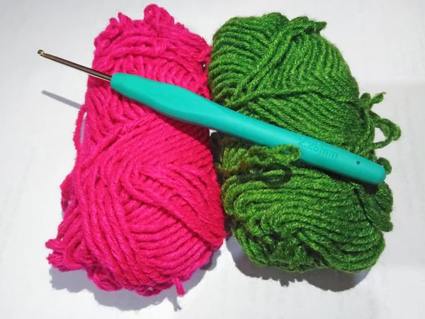 白を基調とした緑とピンクのウール糸と編み針 — ストック写真