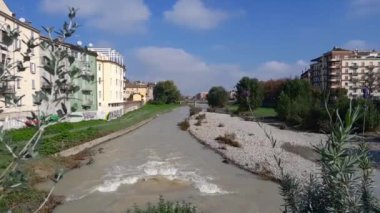 Parma, İtalya - 17 Ekim 2024: Parma şehrindeki güzel nehir. Ponte di mezzo. Nehir suyu dalgaları. Nehir kenarındaki bina.