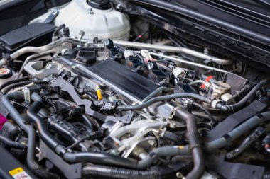 Motordaki arabanın teşhisi. Büyük bir araba servisindeki bir çalışan tarafından araba hizmeti ve denetim. Kaputun altında tüp, sigorta, siyah devre.