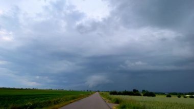 Tarlaların ve asfalt yolların üzerindeki bulutlu gökyüzü. Yüksek kalite 4k görüntü