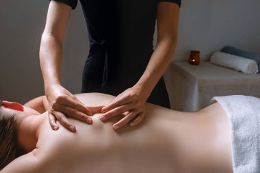 Bir kadın, masaj sırasında kasları, karnı, kalçaları, dizleri, parmakları, başparmakları, bilekleri, göğsü ve gövdesi üzerinde çalışırken rahatlar.