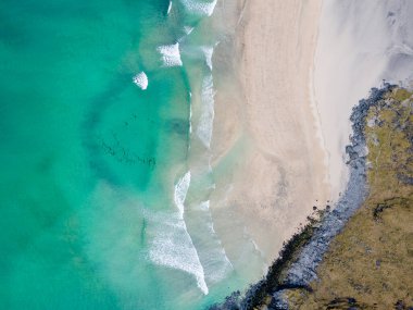 Aerial overhead shot of Kvalvika Beach in Lofoten, Norway, during spring on a clear day with clouds