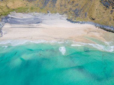Aerial overhead shot of Kvalvika Beach in Lofoten, Norway, during spring on a clear day with clouds