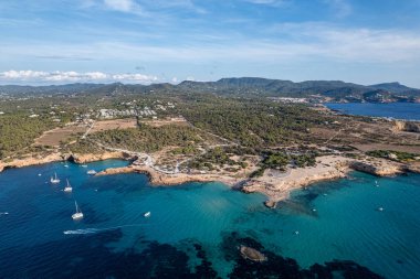 Cala Conta ve Cala Escondida 'nın güneşli bir yaz günü mavi gökyüzü ve turkuaz suyla birlikte İbiza adasındaki sahillerinin havadan çekilmiş fotoğrafları.