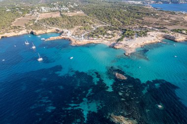 Cala Conta ve Cala Escondida 'nın güneşli bir yaz günü mavi gökyüzü ve turkuaz suyla birlikte İbiza adasındaki sahillerinin havadan çekilmiş fotoğrafları.