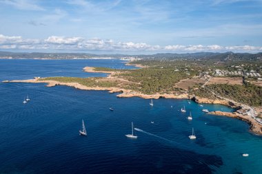 Cala Conta ve Cala Escondida 'nın güneşli bir yaz günü mavi gökyüzü ve turkuaz suyla birlikte İbiza adasındaki sahillerinin havadan çekilmiş fotoğrafları.