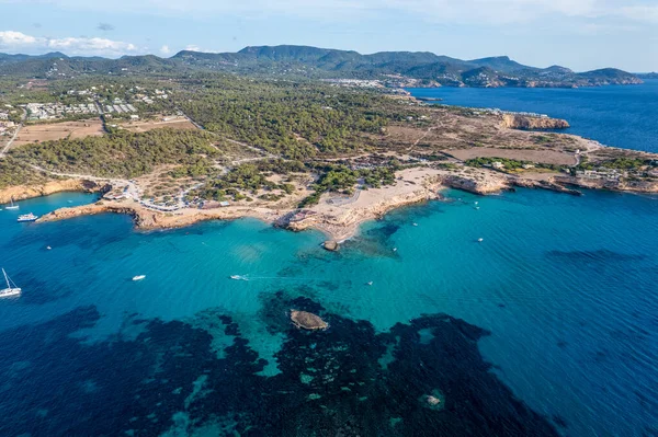 Cala Conta ve Cala Escondida 'nın güneşli bir yaz günü mavi gökyüzü ve turkuaz suyla birlikte İbiza adasındaki sahillerinin havadan çekilmiş fotoğrafları.