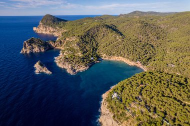 Güneşli bir yaz gününde mavi gökyüzü ve turkuaz suyla Ibiza adasındaki Cala Salada y Cala Saladeta sahillerinin havadan çekilmiş fotoğrafları.