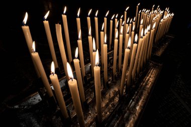 Turuncu alevle yanan bir sürü mum.