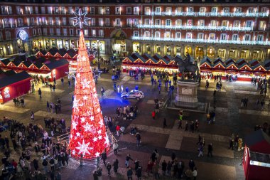 Madrid, İspanya - 12 Aralık 2023: Madrid 'in merkezinde Plaza Belediye Başkanı' nın manzarası, Noel ağacı kırmızıyla aydınlatılmış, Noel ağacı, tipik kırmızı kabinler ile Noel pazarı