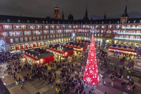 Madrid, İspanya - 12 Aralık 2023: Madrid 'in merkezinde Plaza Belediye Başkanı' nın manzarası, Noel ağacı kırmızıyla aydınlatılmış, Noel ağacı, tipik kırmızı kabinler ile Noel pazarı