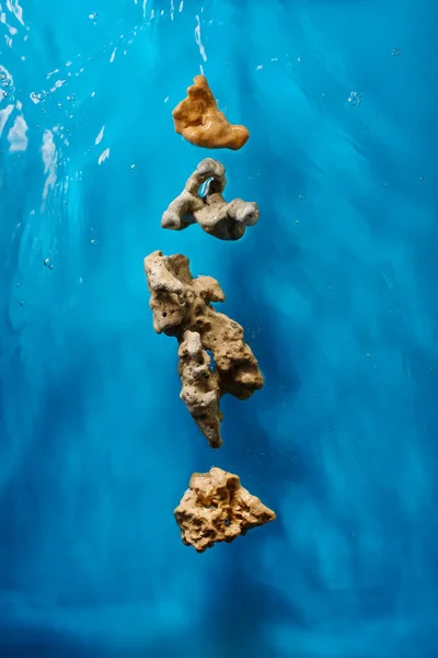 浅蓝色海水中的岩石礁 有波浪和气泡 图库图片