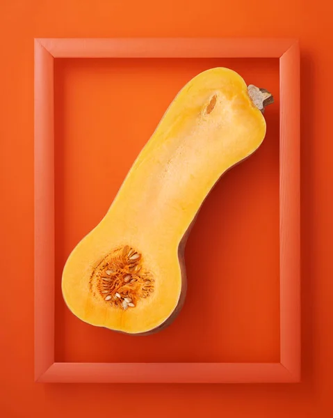 オレンジの背景に木製の画像フレームで半分のカボチャでカット ストック画像