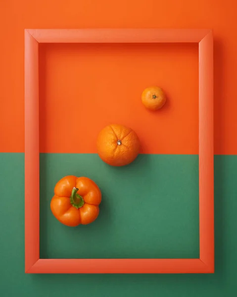 オレンジと緑の背景に木製の画像フレーム内のベルペッパー オレンジとクレメンタイン ストック写真