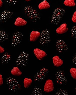 Siyah arka planda böğürtlen ve ahududu yakın 