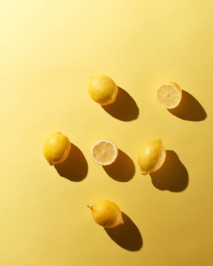 Sarı arka planda dramatik gölgeleri olan yarım limonlar halinde.