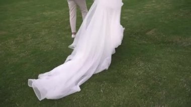 Gelin ve damat el ele, bacaklar kapalı.