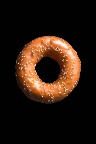 Siyah arka planda izole edilmiş çikolatalı donut.