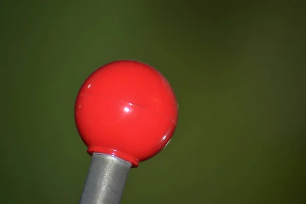 Bulanık bir arkaplanda yuvarlak kırmızı uçlu bir makine kolu ayrıntısı