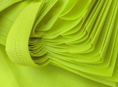 Açık yeşil gözenekli çantalar yığını. Dokumasız kumaş malzemesi. polipropilen çanta