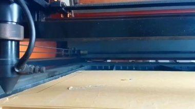 Lazer makinesinin sıcak alevleri kafasını beyaz dumanla kesiyor. Bir sektörde akrilik maddeleri kesme süreci.