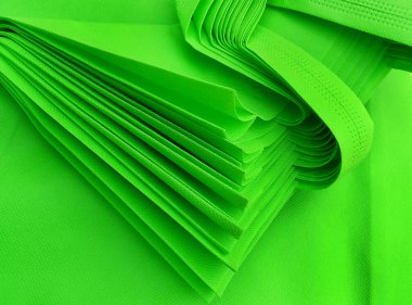 Yeşil gözenekli çanta yığını. Dokumasız kumaş malzemesi. polipropilen çanta