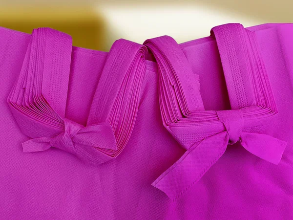 Hromada Dvou Balíčků Porézních Růžových Tašek Netkaná Textilie Vázaná Provazem — Stock fotografie