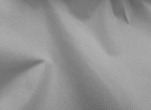 coarse porous gray non-woven fabric surface background. polypropylene fabric texture