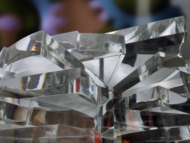 Bulanık bir arka planı olan bir dizi akrilik parça. Endüstriyel lazer makinelerinin kestiği plaklar ya da hediyelik eşyalar için kalın fiberglas ürünler yığını.