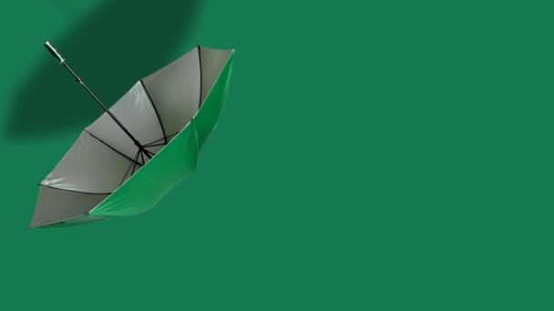 グリーンの背景にまっすぐなハンドルを持つオープン傘 緑の布で傘を浮かべる — ストック動画